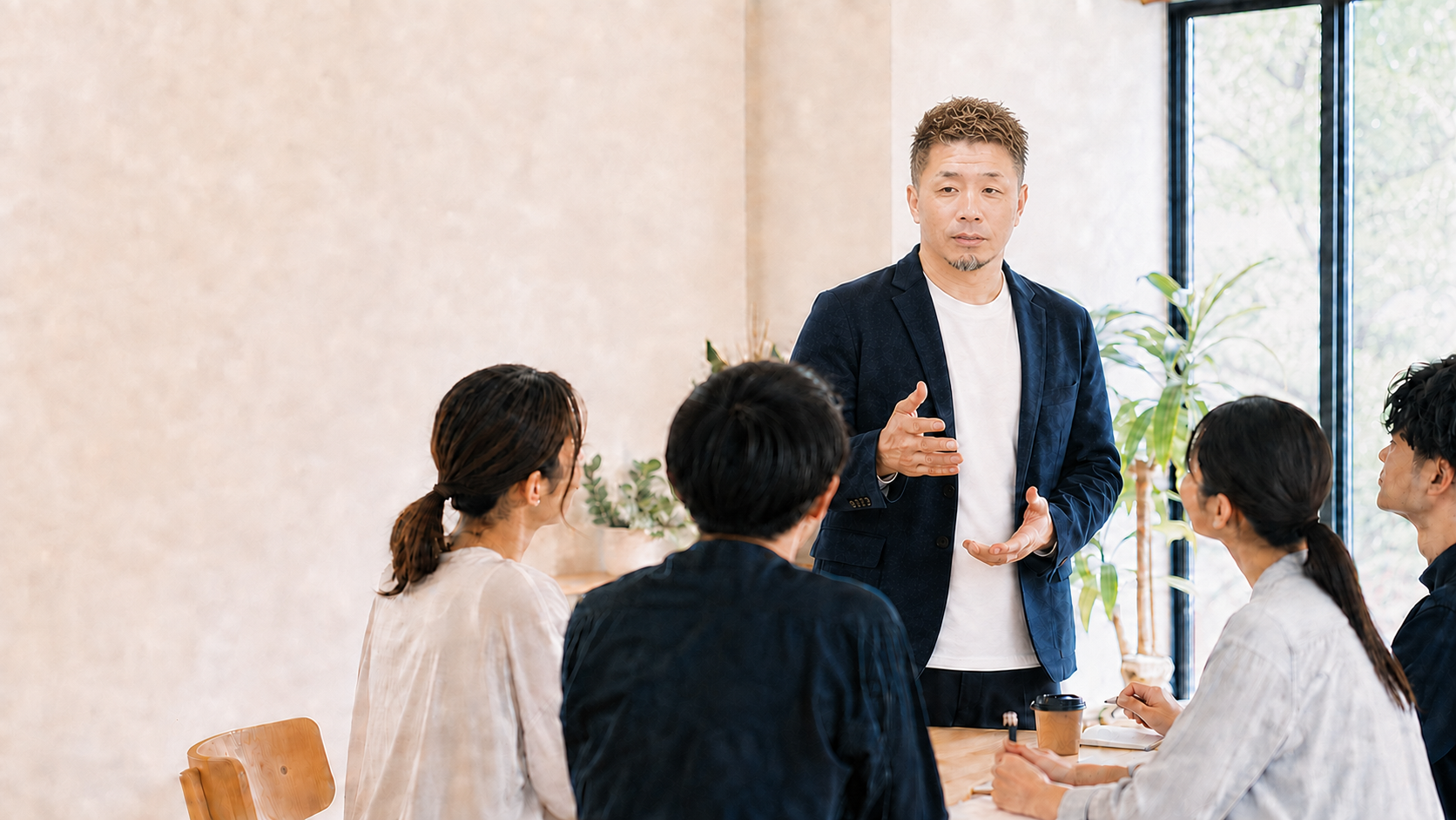 研修会で参加者と対話する講師のイメージ